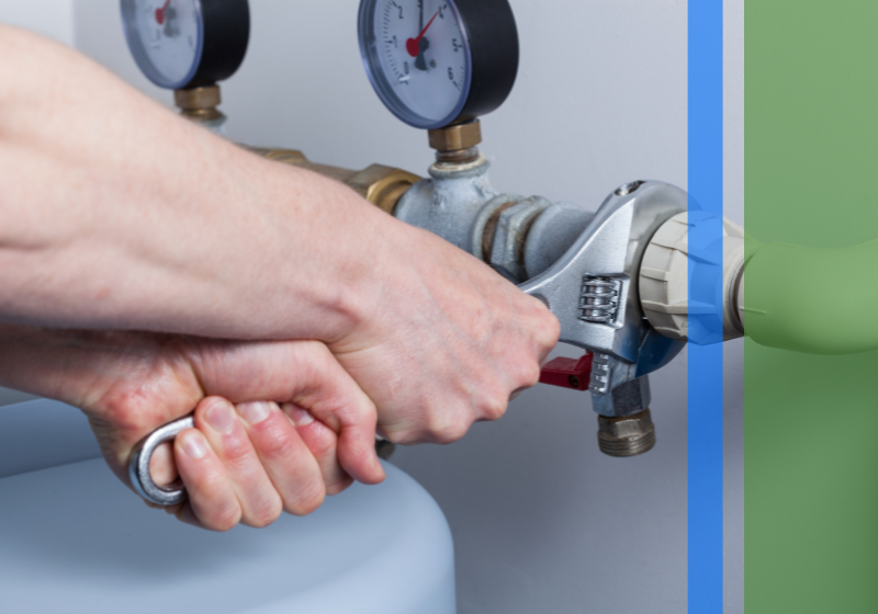 A plumber using a wrench to adjust a sewer line.