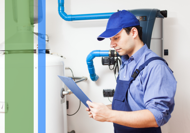 A plumber looking at a clipboard standing in front of a water heater