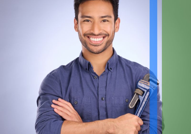 A plumber smiling and holding a wrench