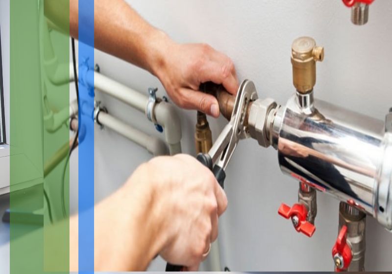 A plumber using a wrench on some commercial plumbing pipes