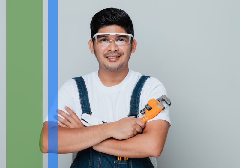 A plumber crossing his arms with a wrench in his hand