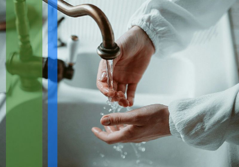 A woman washing her hands in a clean sink basin