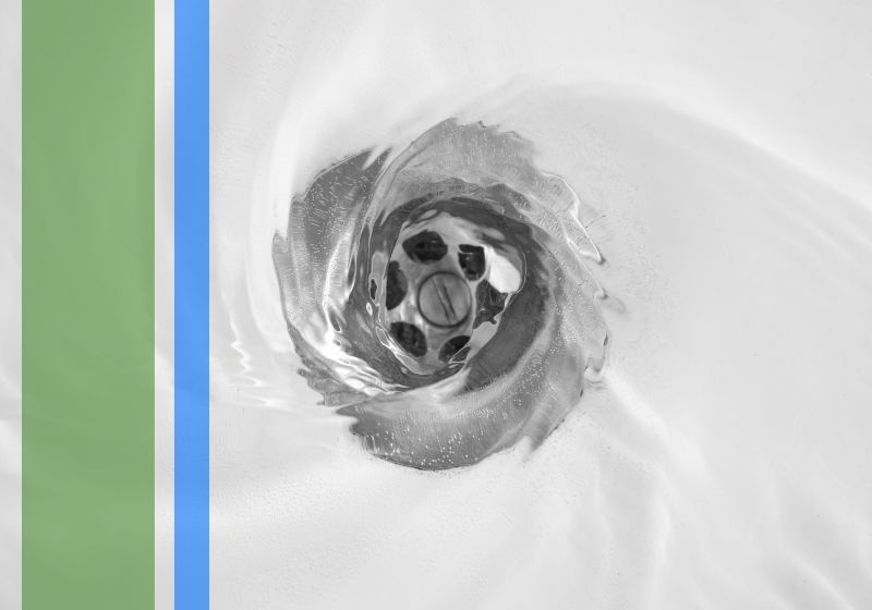 A close-up of a shower drain with water flowing into it.