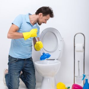 a man plumbing a toilet