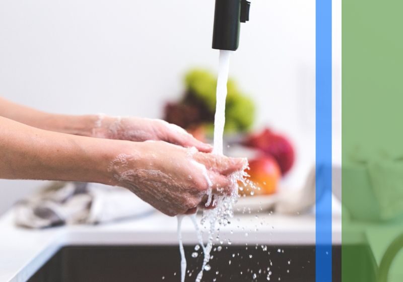 A woman washing her hands in a nice modern kitchen sink