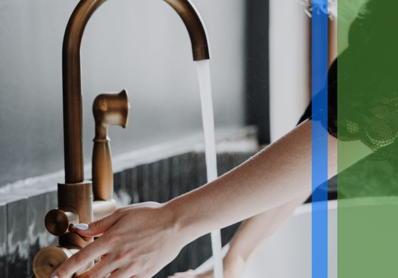 A woman using a copper sink in a nice kitchen
