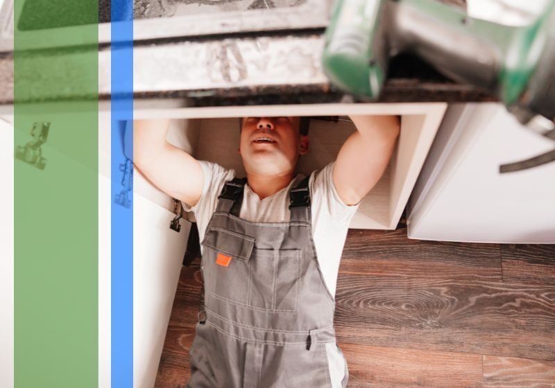 A plumber working under a sink